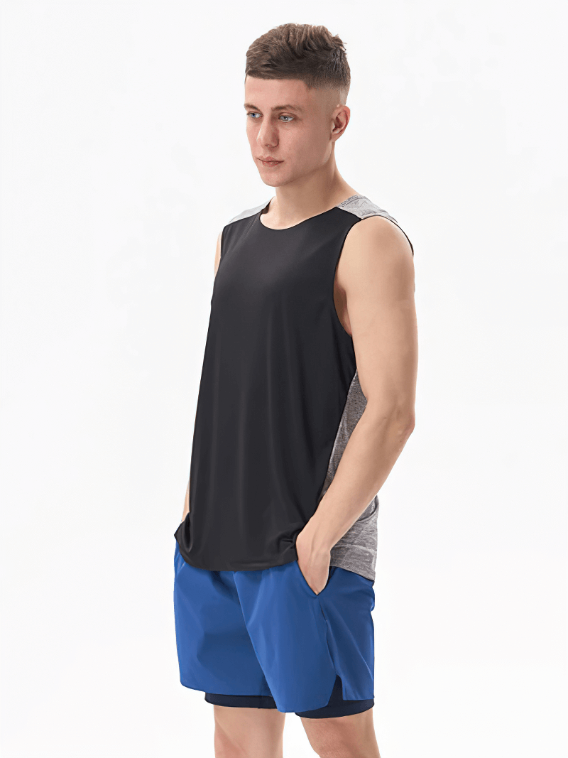 Man wearing gym breathable double-color tank top, black front, gray back, with blue shorts; perfect for workouts.